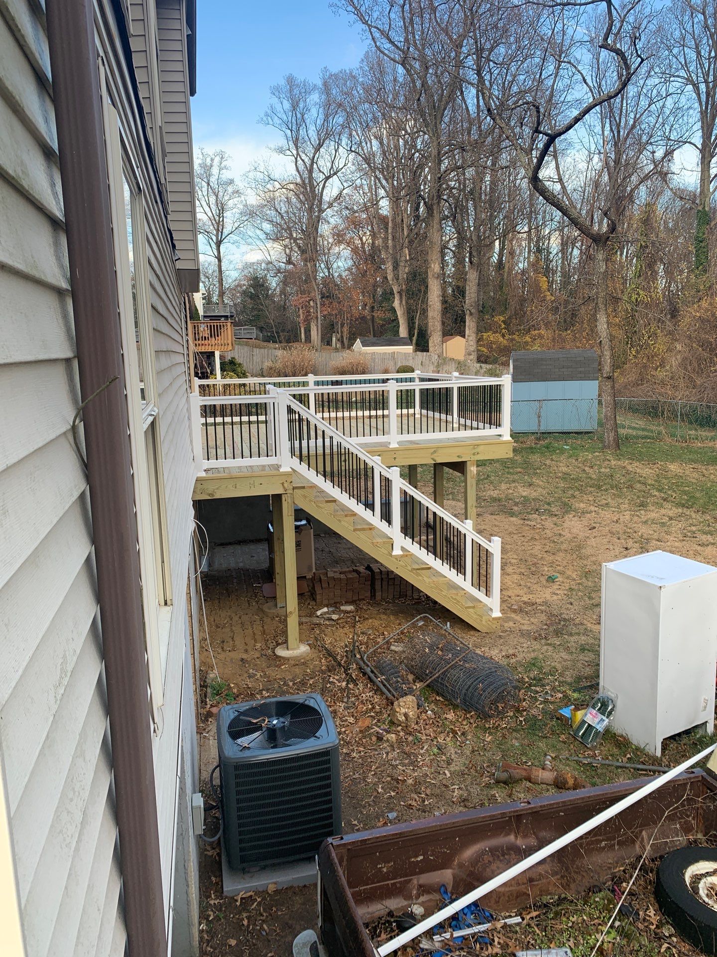 Raised backyard deck with white railings and stairs