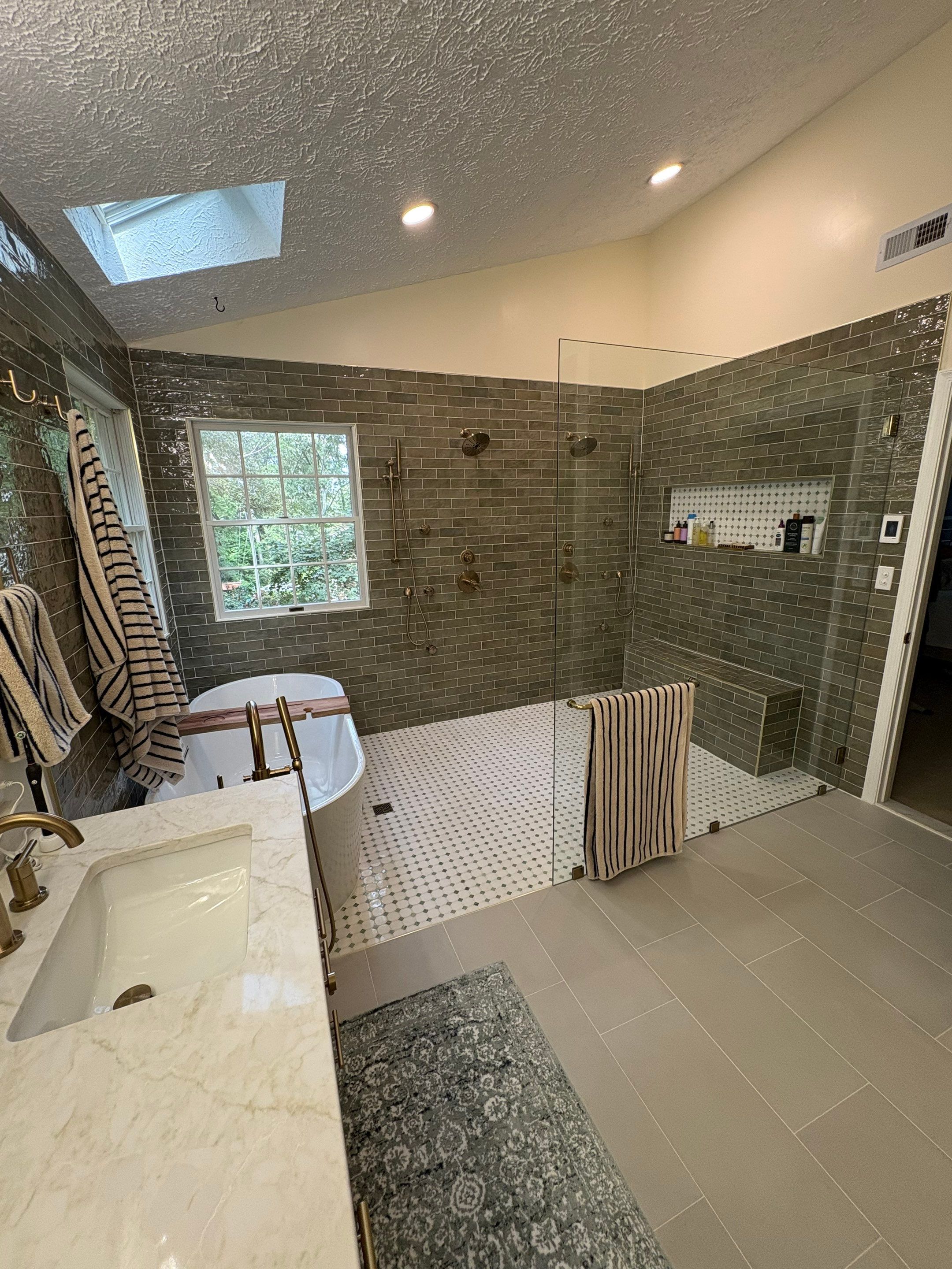 Spacious modern bathroom with glass shower and tub