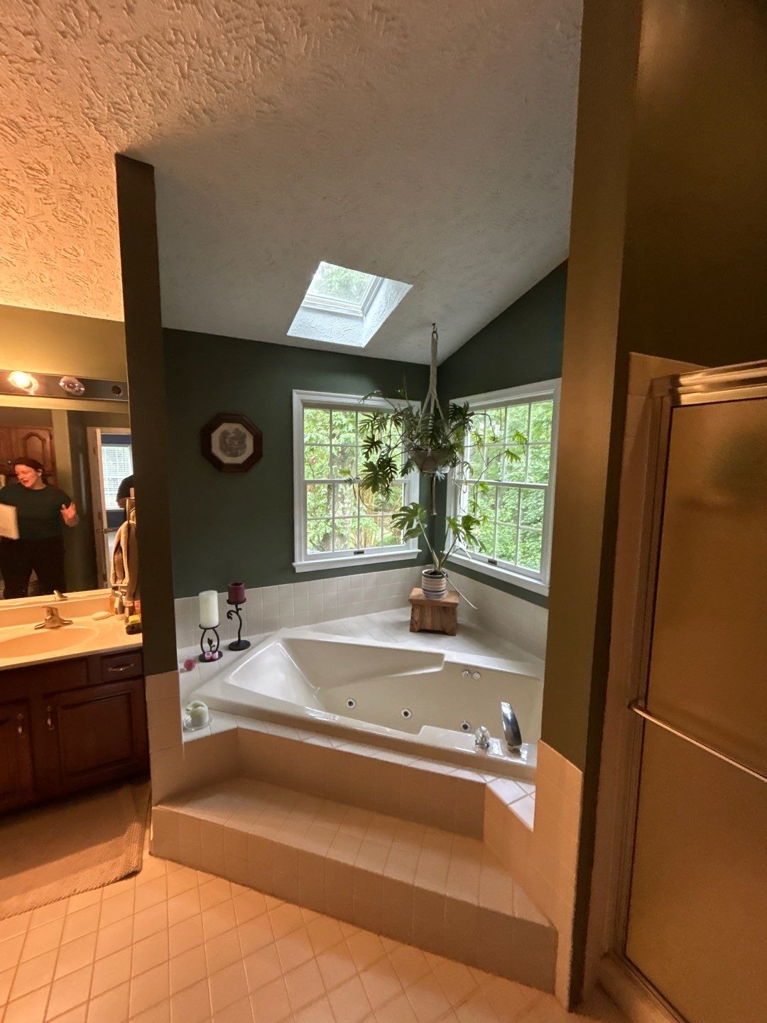 Corner jetted bathtub with skylight and plants
