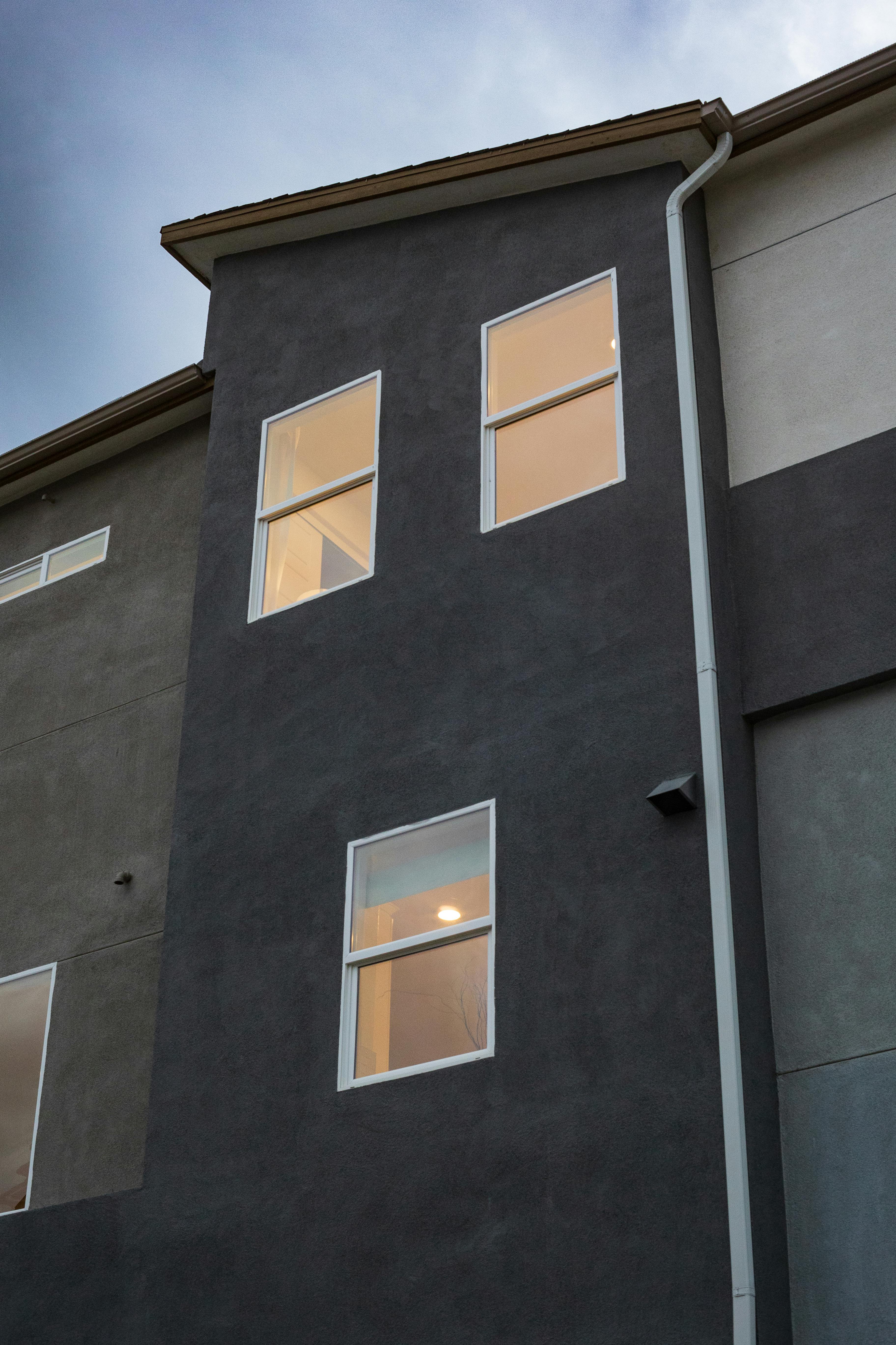Vertical shot of a lit-up modern residential building façade at dusk.