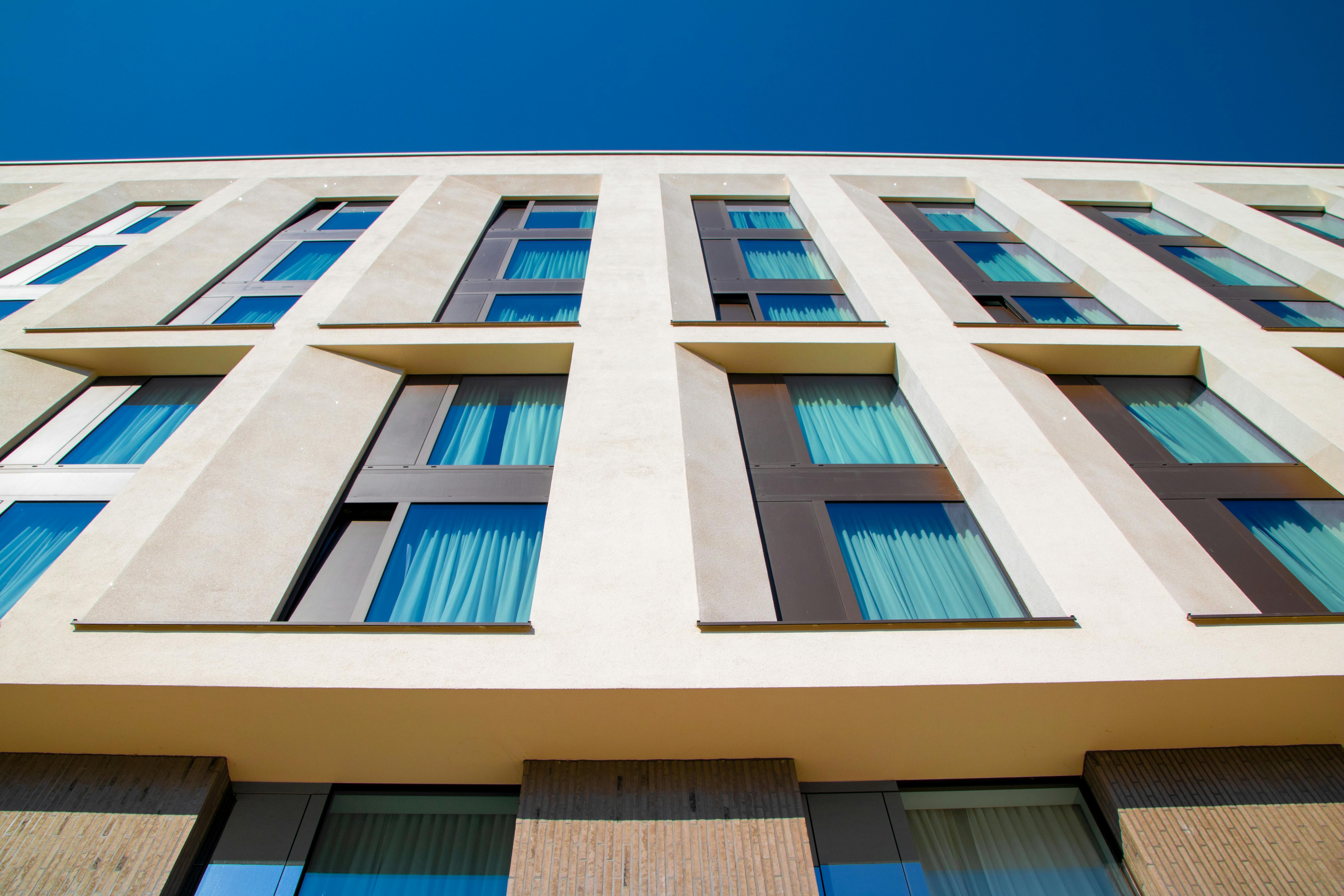 Low-angle view of a modern building facade in Hamburg with clear blue sky.