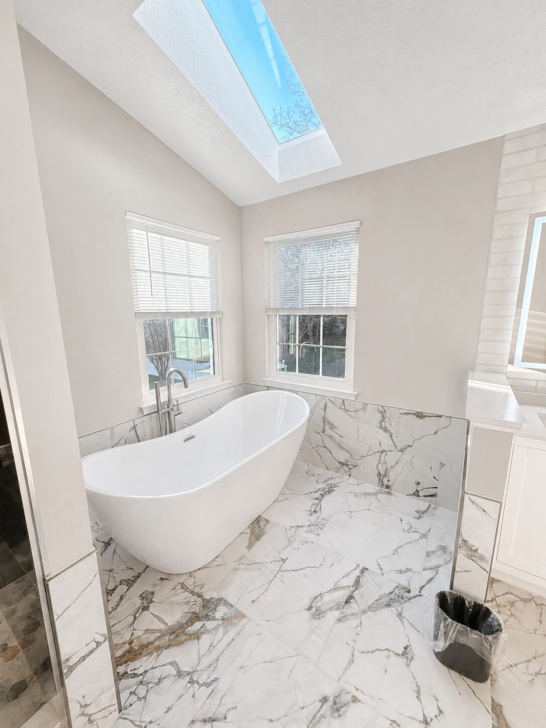 Modern bathroom with freestanding tub and skylight