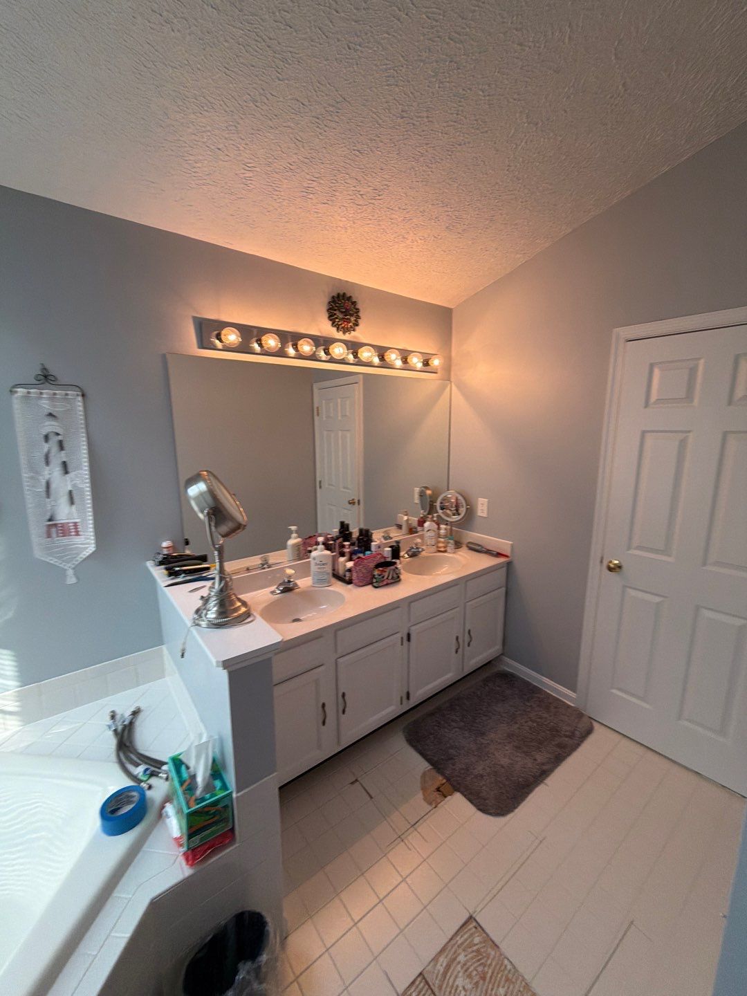 Bathroom with double vanity, mirror, and tub